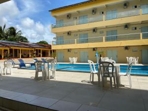 a hotel patio with chairs and a swimming pool at Guará Praia Hotel in Salinópolis +17 photos