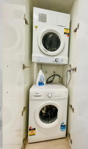 a washer and dryer in a small room at Beautiful studio in Union Street in Auckland