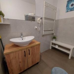 W łazience znajduje się umywalka, lustro i wanna. w obiekcie Apartament Parkowy w mieście Kętrzyn