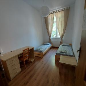 Pokój z 2 łóżkami, biurkiem i oknem w obiekcie Apartament Parkowy w mieście Kętrzyn