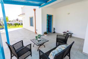 a patio with chairs and a table and a table at Villa Rebecca in Nardò