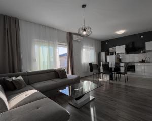 a living room with a couch and a glass table at Apartman Dora in Crikvenica