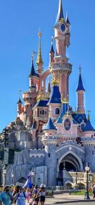 a disney castle with people in front of it at loft SPA nature et détente in Messy