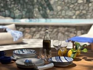 a table with a bottle of wine and plates and glasses at Evelyns Pool Garden in Forio d'Ischia