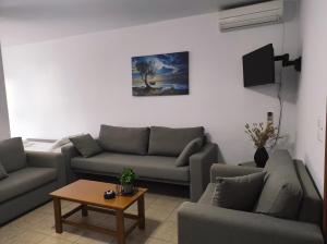 a living room with two couches and a table at Vythos in Adamas