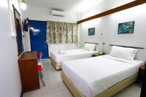 a hotel room with two beds and a television at Chomdoi House Hotel SHA Extra Plus in Chiang Mai