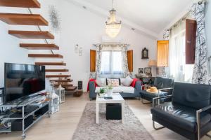 a living room with a couch and a staircase at White & Grey House in Tavira