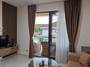 a living room with a glass table in front of a window at Visnjeva Gardens in Višnjevo