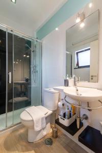 a bathroom with a toilet and a sink and a shower at White & Grey House in Tavira +17 photos