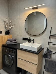 ein Badezimmer mit Waschbecken und Waschmaschine in der Unterkunft Red bridge Resort - Apartament & SPA in Dziwnów