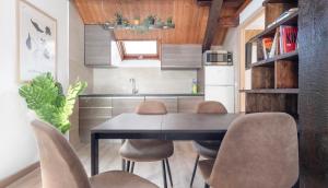 a kitchen with a dining room table and chairs at Ático Canfranc alquiler larga estancia in Canfranc