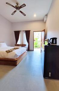 a bedroom with a bed and a ceiling fan at Vinandaka Homestay in Sanur