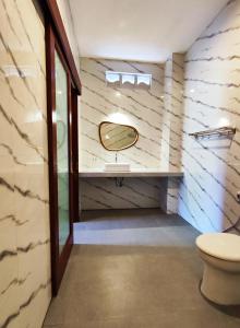a bathroom with a toilet and a mirror at Vinandaka Homestay in Sanur