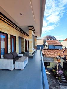 a balcony of a house with a couch at Vinandaka Homestay in Sanur