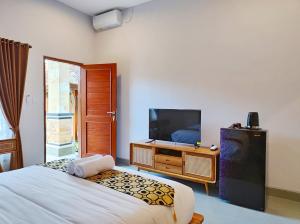 a bedroom with a bed and a tv on a dresser at Vinandaka Homestay in Sanur