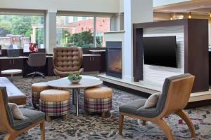 a lobby with a fireplace and chairs and a tv at Residence Inn Atlanta NE/Duluth Sugarloaf in Duluth