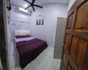 a bedroom with a bed and a wooden door at Liya's Homestay in Kangar