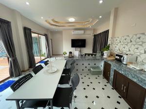 a kitchen with a long table and chairs in a room at P2 Location pool villa in Ban Pak Chong