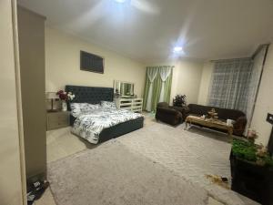 um quarto com uma cama e uma sala de estar em Feel like a home away home em Ajman