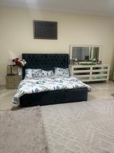 um quarto com uma cama grande e um espelho em Feel like a home away home em Ajman