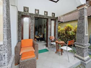 eine Terrasse mit orangefarbenen Stühlen und einem Tisch auf einem Haus in der Unterkunft Rumah Akira Seminyak in Seminyak