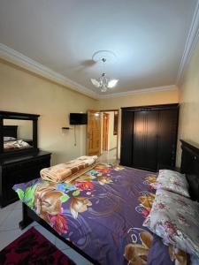 een slaapkamer met 2 bedden en een kroonluchter bij Appartement trois chambres in Berkane +22 foto's