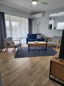 a living room with a blue couch and a table at Denman Motor Inn in Denman