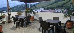 a patio with tables and chairs on a balcony at HOTEL BOUTIQUE NR in Chinácota