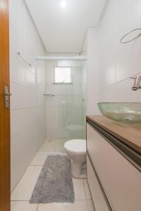 a bathroom with a toilet and a sink at Rental Acomodações Residenciais I in Palhoça +128 photos
