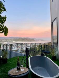 a bath tub with a bottle of wine and a glass at Vista Mare in Wellington