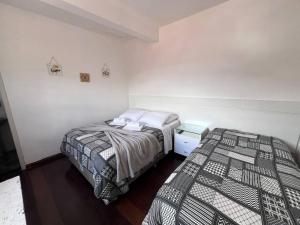 two beds in a small room with at Estadia das Gerais - Suíte Privativa 5 in Ouro Preto