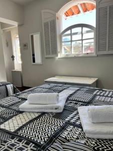 a bedroom with two beds with towels on them at Estadia das Gerais - Suíte Privativa 5 in Ouro Preto +28 photos