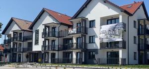 an apartment building with red roofs at PaVoni Apartments Veranda Blu Mare in Łeba
