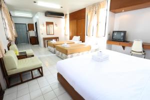 チェンマイにあるChomdoi House Hotel SHA Extra Plusのベッドとリビングルームが備わるホテルルームです。