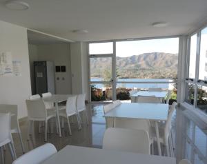 a dining room with tables and chairs and a view of the water at Veneto Village Departamento in Villa Parque Siquiman
