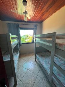 a room with two bunk beds and a window at Aluguel temporada in Arraial do Cabo