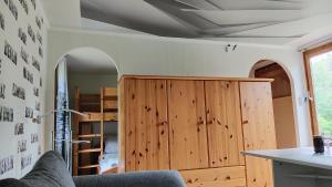 a room with a wooden cabinet and a mirror at Seßles Waldhäusschen Dietzhausen in Suhl +24 photos