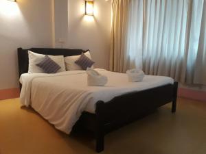 ein Schlafzimmer mit einem großen Bett mit zwei Handtüchern darauf in der Unterkunft S2S Queen Trang Hotel in Trang