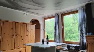a kitchen with a table with a bottle of wine at Seßles Waldhäusschen Dietzhausen in Suhl