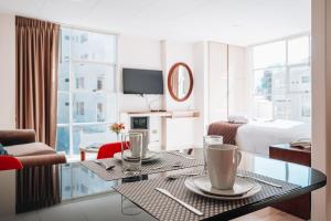 a hotel room with a table and a room with a bed at Fratelli Apart Hotel in La Paz