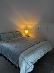 Un dormitorio con una cama grande y una lámpara. en Cozy Top-Floor Stay with Private Bathrooms & Free Parking, en Auckland