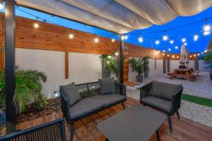 un patio con sillas, una mesa y luces en One Happy Getaway on One Happy Island, en Noord