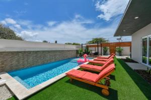 un patio trasero con piscina con tumbonas y piscina en One Happy Getaway on One Happy Island, en Noord