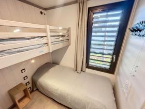 une petite pièce avec un lit et une fenêtre dans l'établissement Chalet de Standing à Jullouville: 6 Couchages, Piscine Chauffée, Proche Plage et Commerces, WiFi Gratuit - FR-1-361-548, à Jullouville 22 autres photos