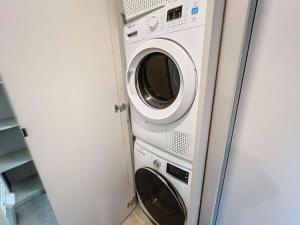 une laveuse et une sécheuse dans une petite pièce dans l'établissement Chalet de Standing à Jullouville: 6 Couchages, Piscine Chauffée, Proche Plage et Commerces, WiFi Gratuit - FR-1-361-548, à Jullouville