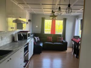 une cuisine et un salon avec un canapé dans l'établissement Chez Mayan et Doly 206 rue des Sapins, à Clarke City