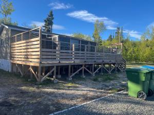 une grande maison en bois avec une poubelle à côté dans l'établissement Chez Mayan et Doly 206 rue des Sapins, à Clarke City