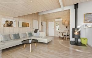un salon avec un canapé blanc et une cheminée dans l'établissement 3 Bedroom Lovely Home In Ålbæk, à Ålbæk