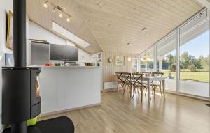 Il comprend une cuisine et une salle à manger avec une cheminée et une table. dans l'établissement 3 Bedroom Lovely Home In Ålbæk, à Ålbæk