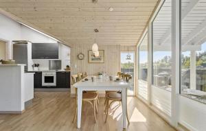 une cuisine et une salle à manger avec une table et des chaises blanches dans l'établissement 3 Bedroom Lovely Home In Ålbæk, à Ålbæk